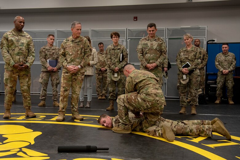 U.S. Air Force Staff Sgt. Joseph McGuire, standards and evaluations, and U.S. Air Force Staff Sgt. Brendan Bartoo, Phoenix Raven Qualification Course instructor, both assigned to the 421st Combat Training Squadron, demonstrate how to apprehend an adversary to Air Force Chief of Staff Gen. David L. Goldfein and Chief Master Sgt. of the Air Force Kaleth O. Wright during their visit to the U.S. Air Force Expeditionary Center as part of 2019 Fall Phoenix Rally, Oct. 9, 2019, at Joint Base McGuire-Dix-Lakehurst, New Jersey. Fall Phoenix Rally is a three-day summit focused on understanding leadership roles in emerging issues with Air Mobility Command, bringing together leadership and spouses from throughout the command.