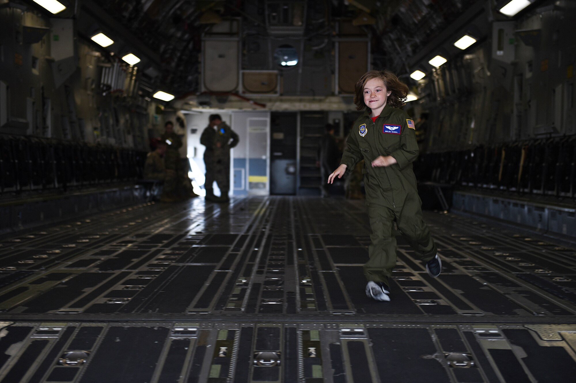 Declan Gaskill, Joint Base Lewis-McChord (JBLM) Pilot for a Day (PFAD) participant, runs through the cargo bay of a C-17 Globemaster III on JBLM, Wash., May 21, 2019. Participants of the PFAD program receive a U.S. Air Force pilot’s flight suit along with a jacket and cap, a C-17 small-scale replica, and a photo album to commemorate their day.