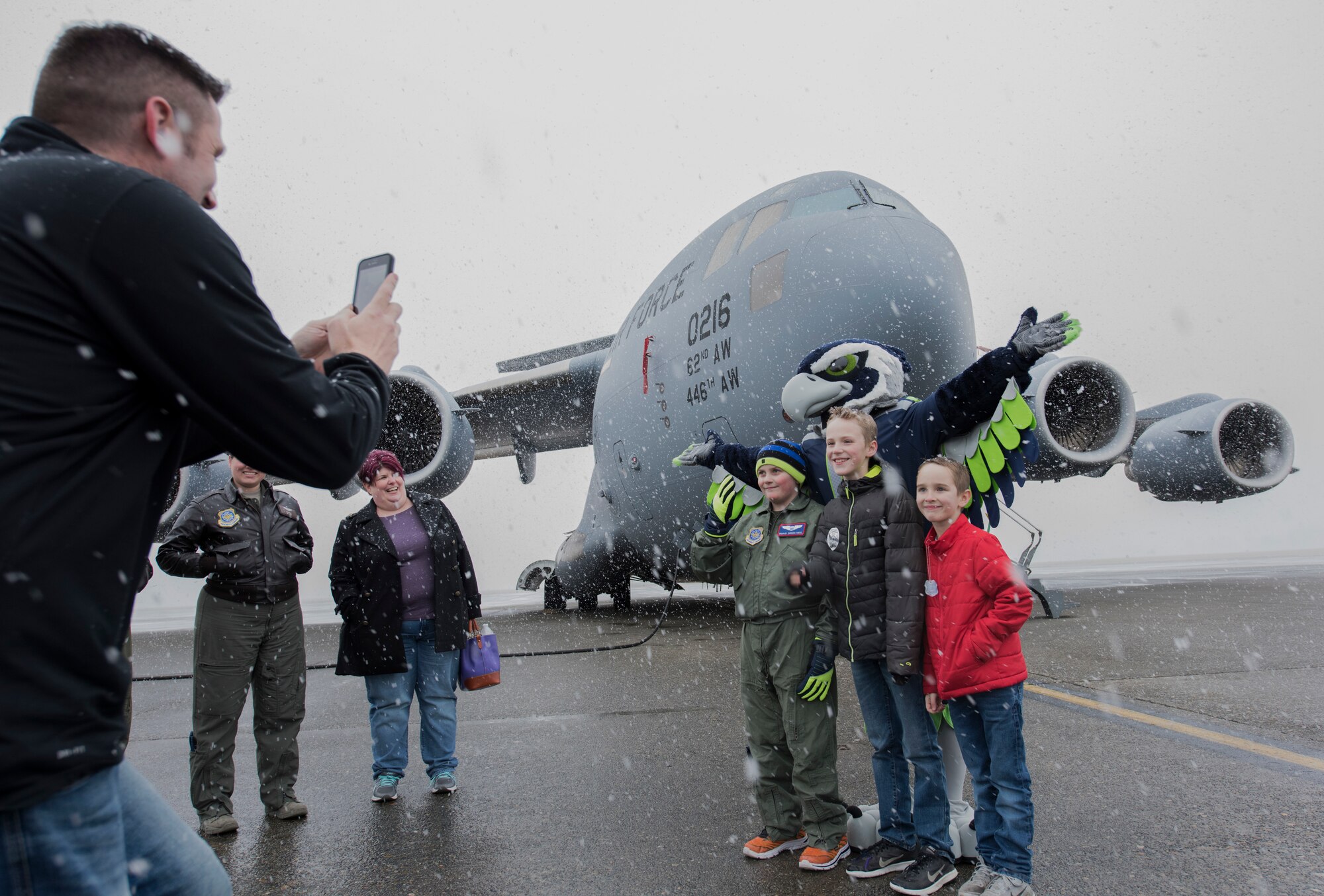McKay Neel (third from left), McChord’s newest Pilot for a Day participant, and two friends take a photo with Blitz, Seattle Seahawks mascot, during a tour of McChord Field at Joint Base Lewis-McChord, Wash., Feb. 20, 2018. McKay was joined on his tour by his parents, two friends, their dad and 4th Airlift Squadron personnel.