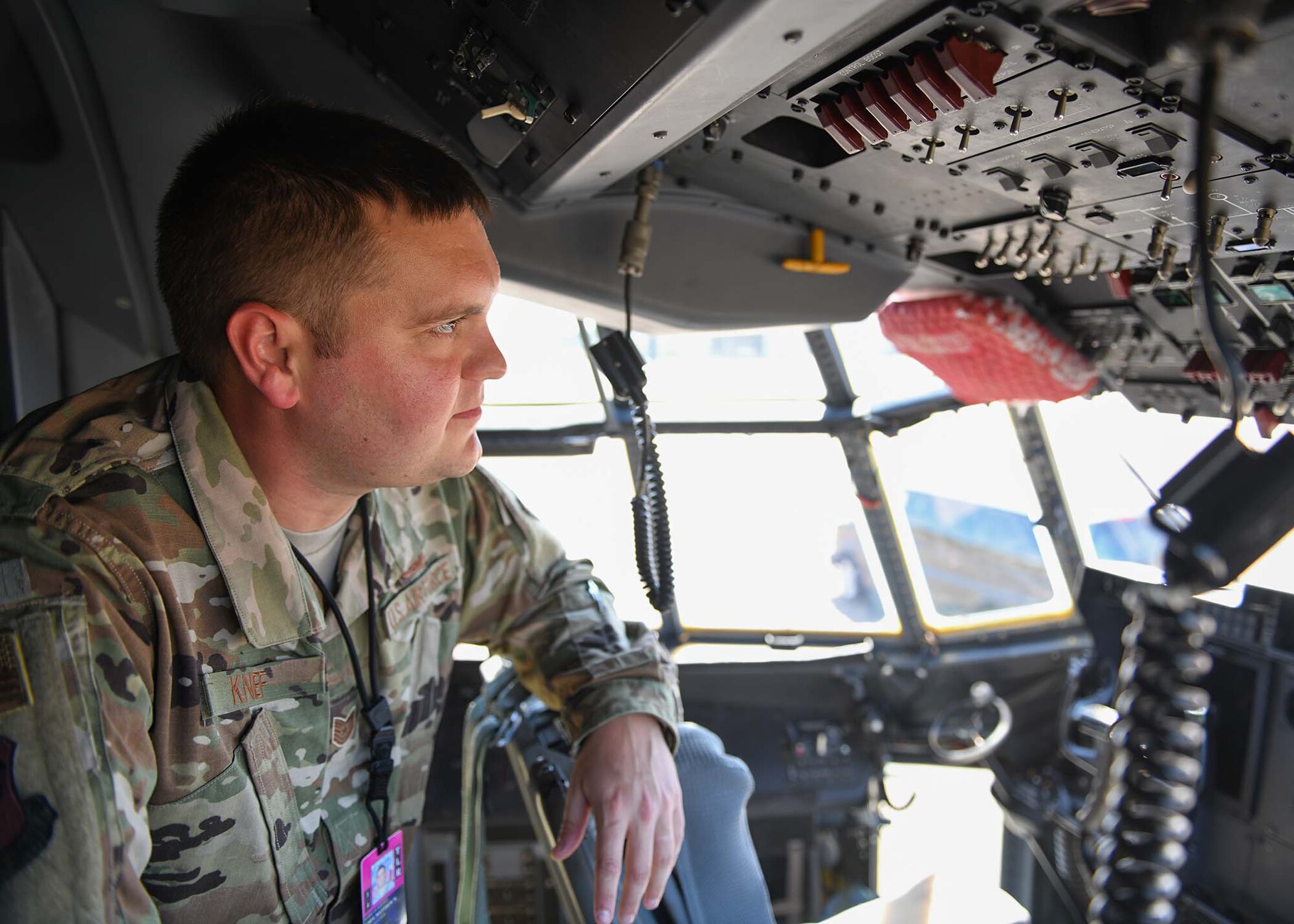 An Airman sits in the cockpit of a C-130