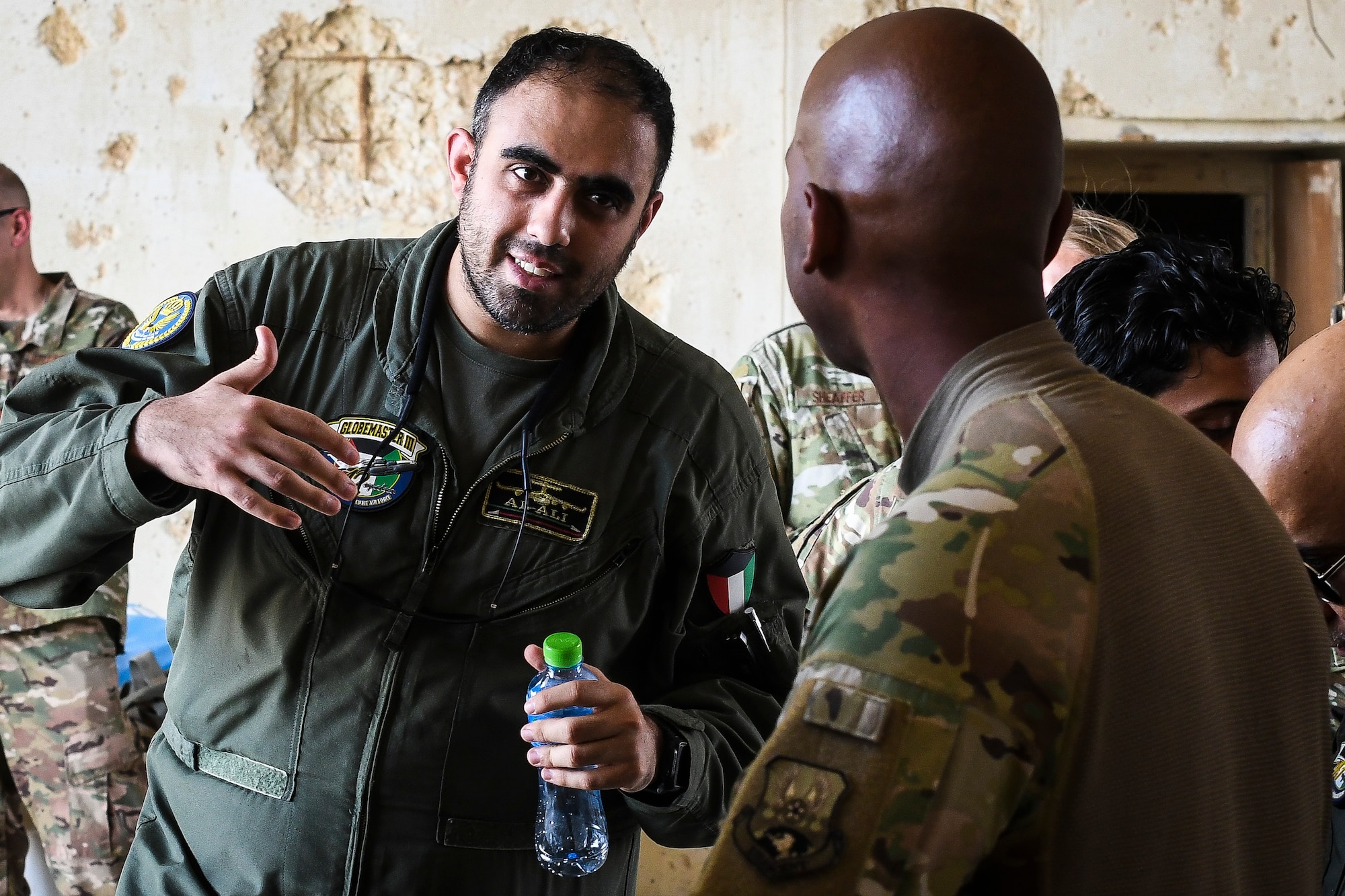 U.S. Air Force service members give a tour of their work area to Kuwaiti air force members at Ahmed Al Jaber Air Base, Kuwait, Sept. 25, 2019. Both militaries participated in a subject matter expert exchange on cargo transportation and preparation, learning about each other’s processes and providing feedback. (U.S. Air Force photo by Senior Airman Lane T. Plummer)