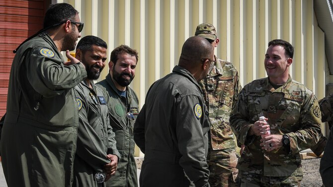 U.S. Air Force service members laugh with their Kuwaiti air force counterparts while they tour U.S. units at Ali Al Salem Air Base, Kuwait, Sept. 24, 2019. Both militaries participated in a subject matter expert exchange on cargo transportation and preparation, learning about each other’s processes and providing feedback. (U.S. Air Force photo by Senior Airman Lane T. Plummer)