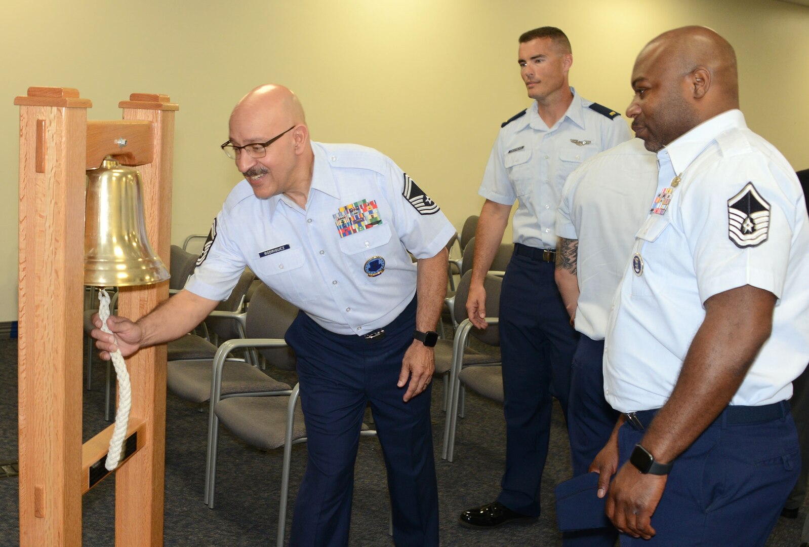 Senior Master Sgt. Randy Rodriguez, superintendent of the Air Force Recruiting Total Force Recruiting Cell at Joint Base San Antonio-Randolph, rings the bell signifying Air Force Recruiting Service reached their yearly goal. Each person at AFRS headquarters gets a turn ringing the bell celebrating making goal.