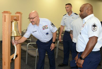 Senior Master Sgt. Randy Rodriguez, superintendent of the Air Force Recruiting Total Force Recruiting Cell at Joint Base San Antonio-Randolph, rings the bell signifying Air Force Recruiting Service reached their yearly goal. Each person at AFRS headquarters gets a turn ringing the bell celebrating making goal.