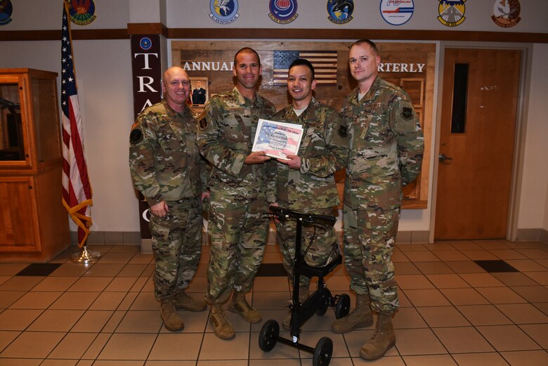U.S. Air Force Col. Zachery Jiron, center left, 60th Air Mobility Wing vice commander, Chief Master Sgt. Matt Pulsipher, left, 60th Comptroller Squadron and Wing Staff Agency superintendent, and Master Sgt. Randel Moser, right, 660th Aircraft Maintenance Squadron aircraft section chief, recognize Staff Sgt. Mark Hedge, center right, 660th Aircraft Maintenance Squadron Aerospace Propulsion craftsman, as Warrior of the Week Oct. 8, 2019, at Travis Air Force Base, California. Hedge was recognized as the 60th Air Mobility Wing Warrior of the Week for Oct. 6-12, 2019. The program highlights a Travis Airman or noncommissioned officer for his or her outstanding performance. (U.S. Air Force photo by Airman 1st Class Cameron Otte)