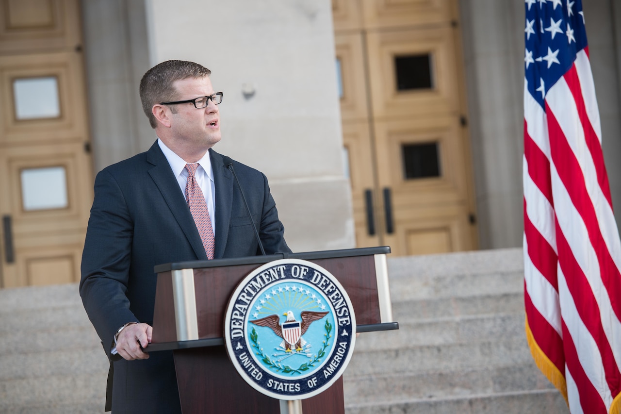 Army Secretary Ryan D. McCarthy speaks at a lectern.