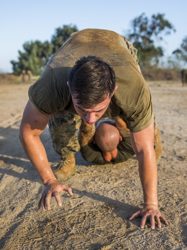U.S. Marine Corps Cpl. Patrick Espinola, a chemical, biological, radiological and nuclear defense specialist with the 13th Marine Expeditionary Unit, I Marine Expeditionary Force, executes a pistol belt drag with Gunnery Sgt. Artur Shvartsberg, the force fitness instructor with the 13th MEU, I MEF, during a unit physical training event at Camp Pendleton Calif., September 6, 2019.