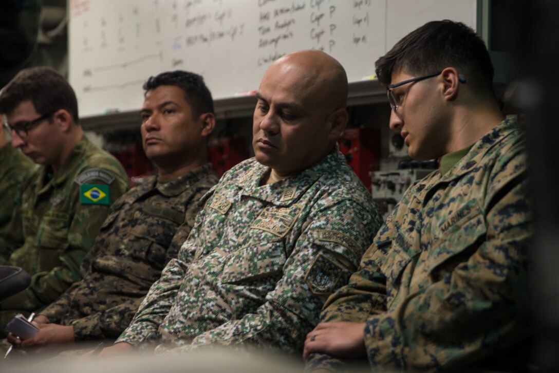 U.S. Marine Corps Sgt. Milton Rendonduque, a satellite operator with Special Purpose Marine Air-Ground Task Force-WASP, translates for a member of the Colombian Naval Infantry during a humanitarian aid planning exercise aboard the USS Wasp (LHD 1), at sea, Sept. 27, 2019.