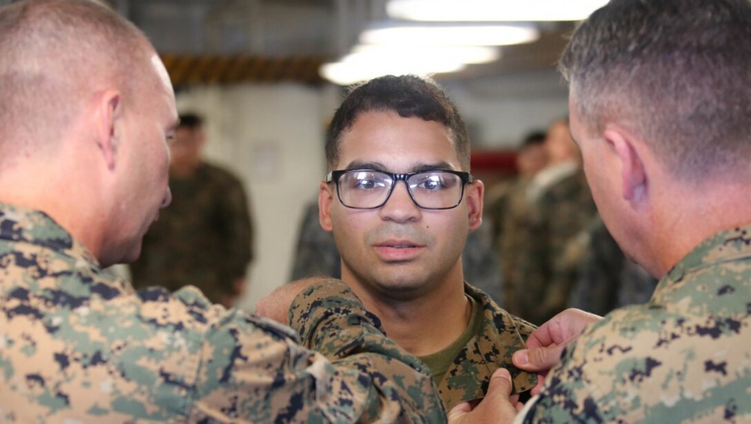 U.S. Marine Cpl. Kelvin Vittini, an aviation maintenance technician with the Special Purpose Marine Air-Ground Task Force-WASP has his chevrons placed on his collar by Col. Andrew T. Priddy, the commanding officer and Sgt. Maj. Stuart D. Glass, the sergeant major of SPMAGTF-WASP during a promotion ceremony aboard the USS Wasp (LHD-1), in the Pacific Ocean, Oct. 1, 2019.