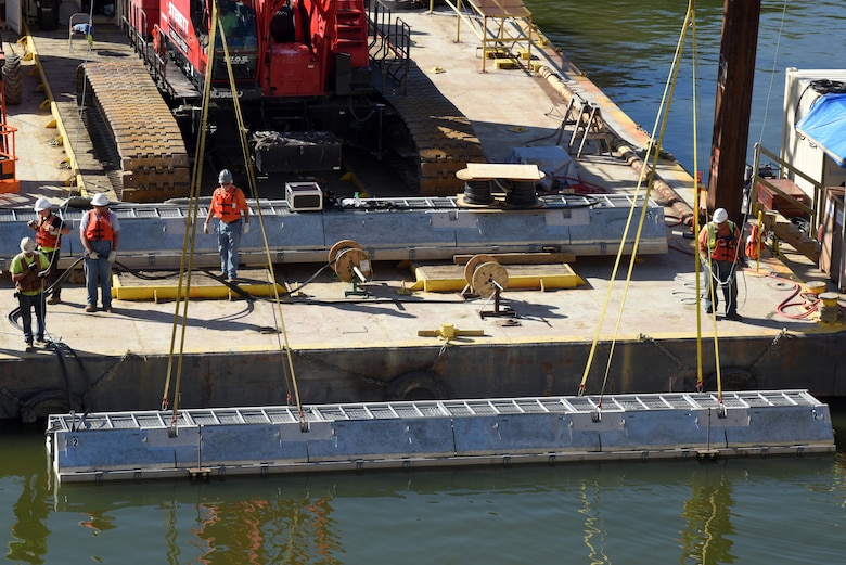 Fish Guidance Systems crew installs a section of the bio acoustic fish fence into the water Oct. 9, 2019 below Barkley Lock in Grand Rivers, Ky. The BAFF is expected to be operational in a few weeks, and a field trial is set to test the effectiveness.  The project involves multiple agencies and partners, including U.S. Fish and Wildlife Service, Kentucky Department of Fish and Wildlife Resources, U.S. Army Corps of Engineers Nashville District, U.S. Geological Survey and Tennessee Wildlife Resources Agency. (USACE photo by Lee Roberts)