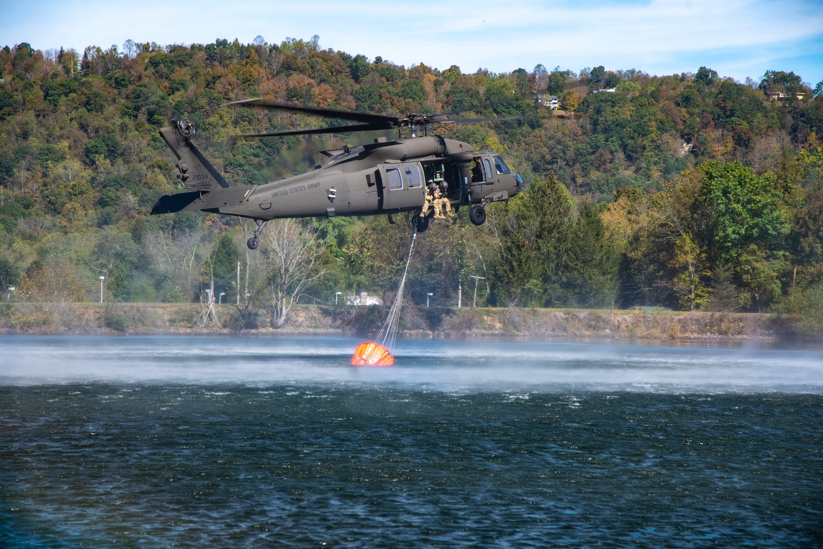 Members of West Virginia Army National Guard Company C, 1st Battalion, 150th Aviation Regiment, practice using a helicopter bucket to fight fires at Camp Dawson, West Virginia, Oct. 10, 2019. The training prepares aircrew members to respond with civilian firefighting agencies to wildfires.