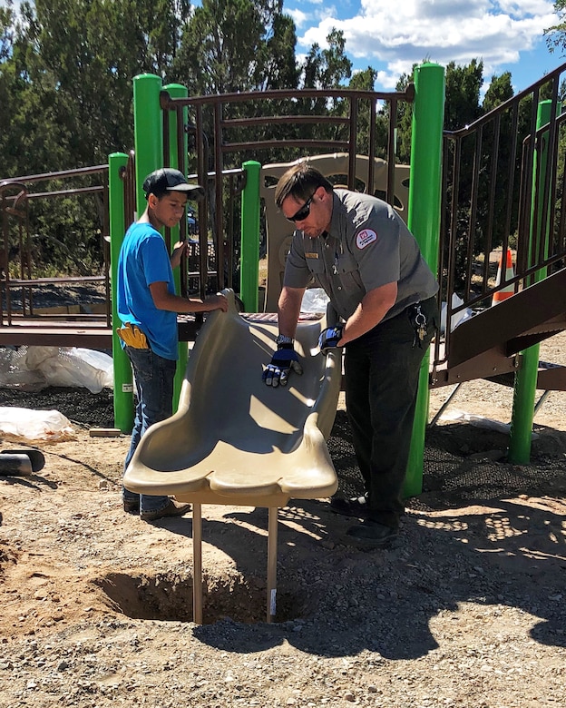 Abiquiu Lake project office manager John Mueller, right, works with a volunteer on the installation of an ADA-accessible playground at the lake on National Public Lands Day, Sept. 28, 2019.