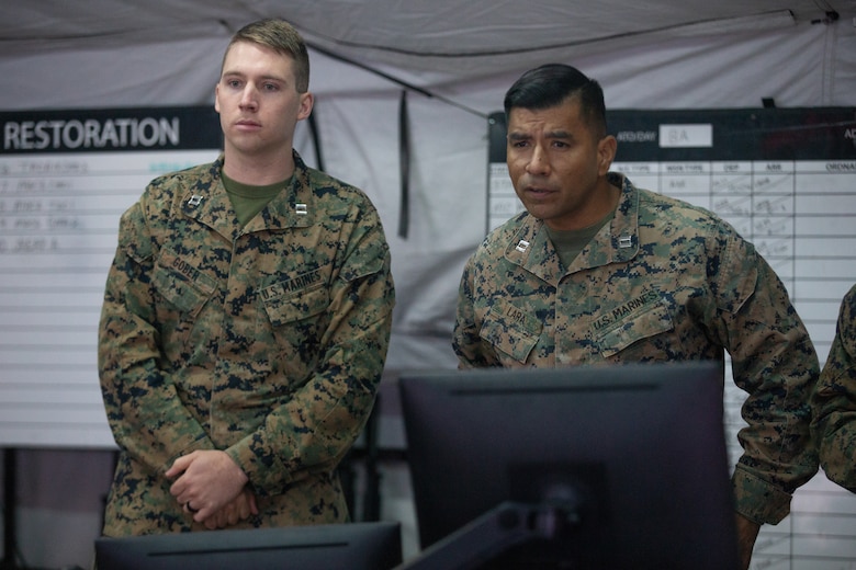 Marine Capt. Zachariah A. Gober, left, and Capt. Cristobal V. Lara participate in a morning brief during Exercise Pegasus Flight at Marine Corps Air Station Cherry Point, North Carolina, Oct. 2, 2019. Marine Tactical Air Command Squadron 28 supported Pegasus Flight by planning, commanding, directing and supervising all air operations as the tactical air command center for the exercise. Gober is an air support control officer and Lara is a low altitude air defense officer with MTACS-28, Marine Air Control Group 28, 2nd Marine Aircraft Wing. (U.S. Marine Corps photo by Pfc. Steven M. Walls)