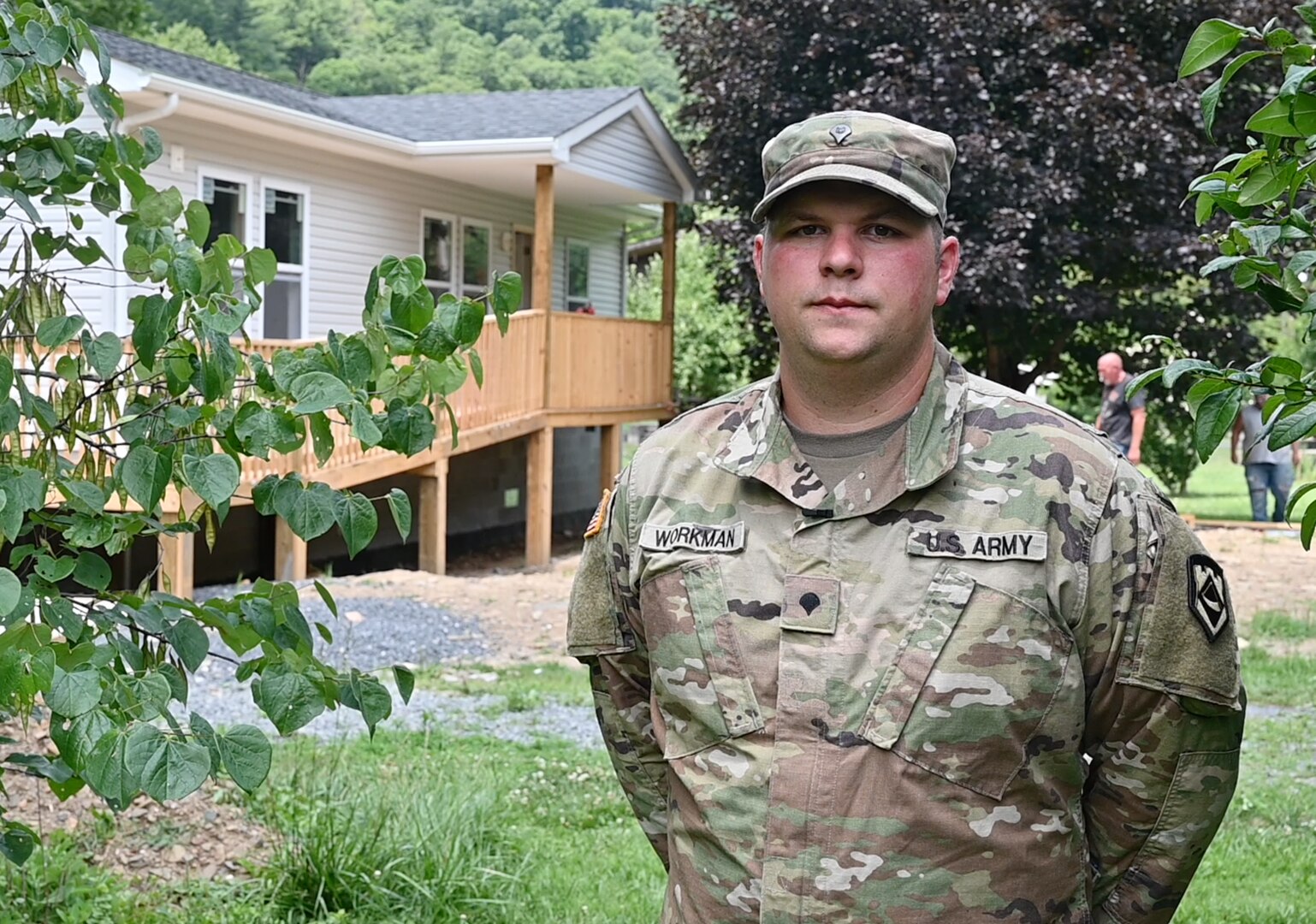 Soldier standing in front of completed home.