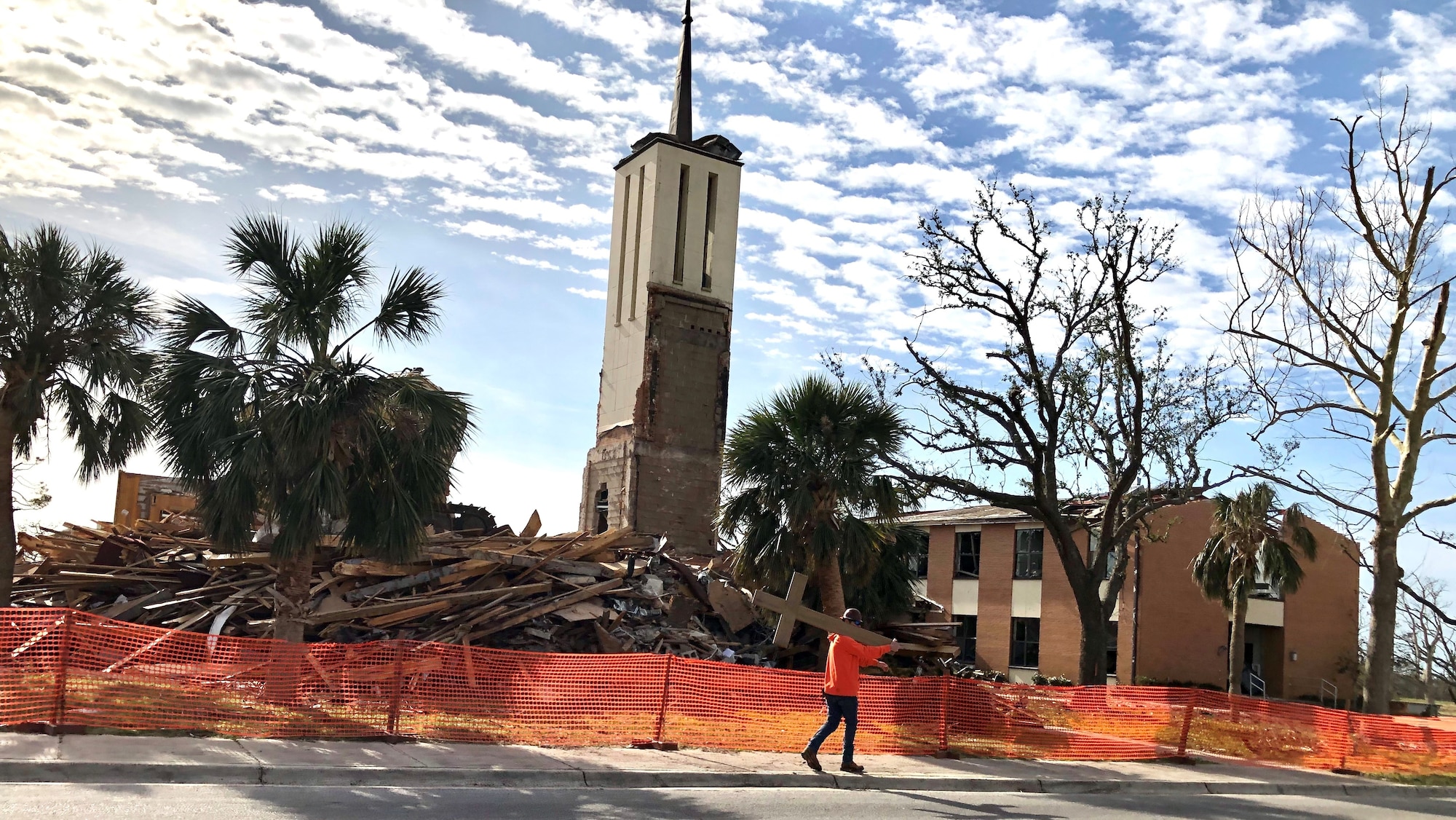 A construction worker carries a cross after an excavator demolished the Tyndall Air Force Base, Florida, chapel in February. The Tyndall Chapel was unable to be restored after sustaining immense damage from Hurricane Michael on Oct. 10, 2018. (U.S. Air Force photo)