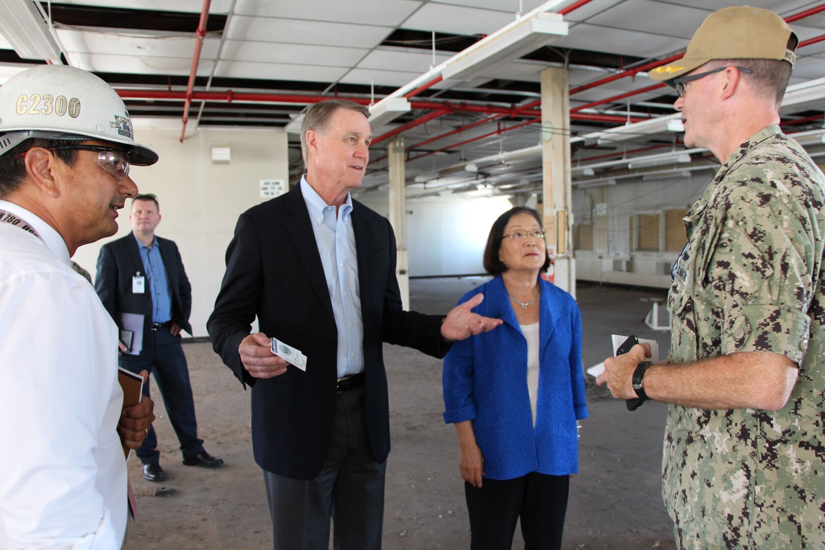 Commander of Pearl Harbor Naval Shipyard and Intermediate Maintenance Facility Capt. Greg Burton and Nuclear Engineering & Planning Manager Kaipo Crowell discuss plans for Building 1’s third fl oor with Sen. David Perdue of Georgia and Sen. Mazie Hirono of Hawaii. The two Senators are the Chair and Ranking Member of the Subcommittee on Seapower, which is part of the Senate Armed Services Committee.