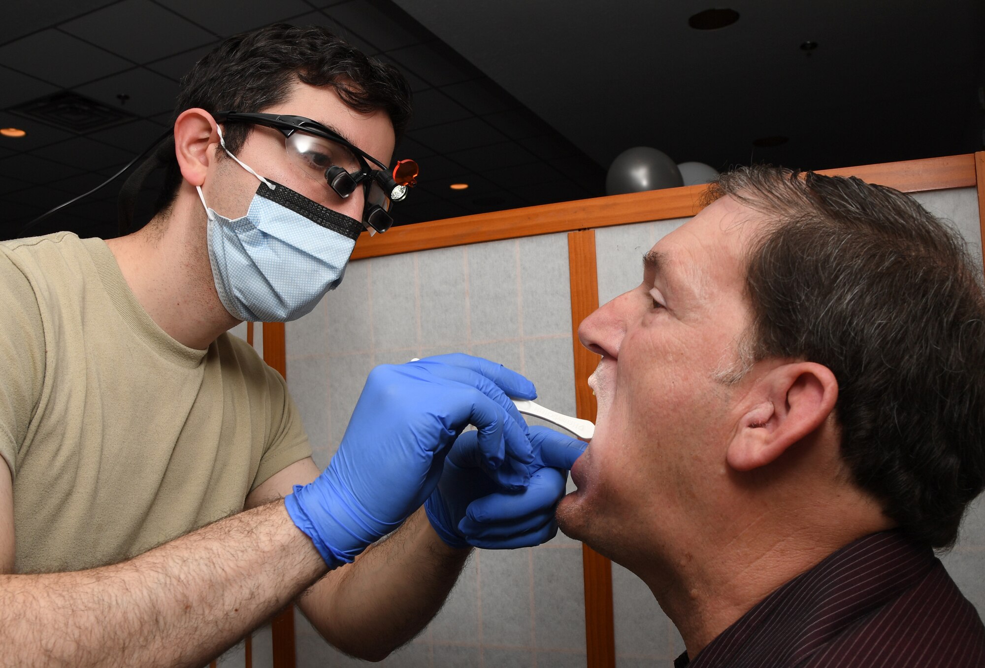 U.S. Air Force Capt. Stephan Javaheri, 81st Dental Squadron general dentist, conducts a dental exam on retired Tech. Sgt. Raymond Klein during the 81st Medical Group Health Expo inside the Keesler Medical Center at Keesler Air Force Base, Mississippi, Oct. 4, 2019. The 81st MDG hosted the walk-in event which included screenings for multiple types of cancer and chronic diseases in honor of Breast Cancer Awareness Month. (U.S. Air Force photo by Kemberly Groue)