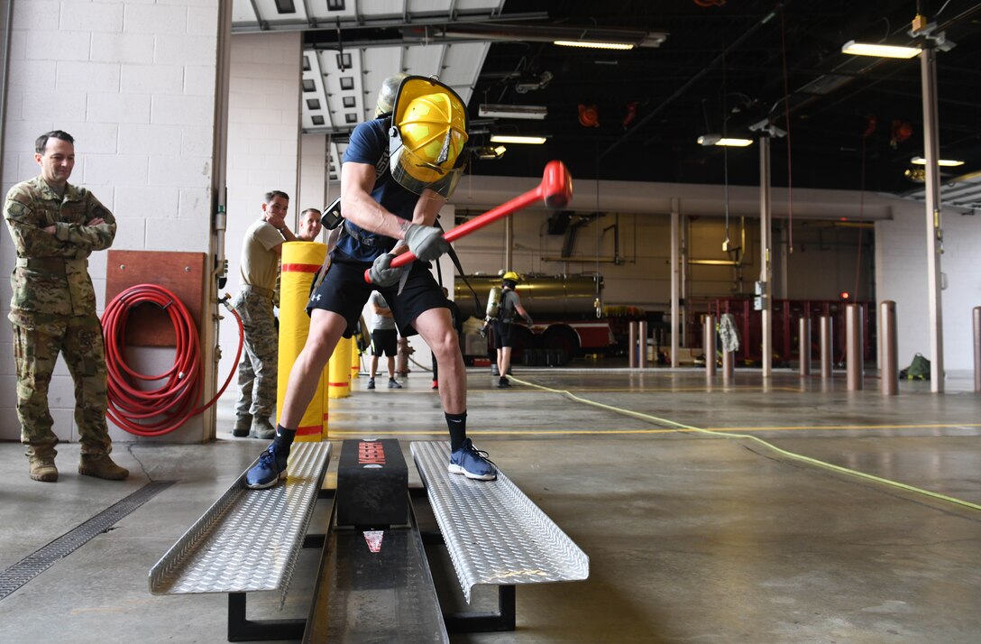 Senior Airman Cody Quinones, 22nd Logistics Readiness Squadron fleet management analyst, brings down a sledgehammer on a Keiser FORCE Machine during the Fire Muster competition Oct. 10, 2019, at McConnell Air Force Base, Kan. The Keiser event, which simulates forcible entry used by firefighters to enter burning buildings, requires participants to hit a 150-pound weight for a distance of five feet. (U.S. Air Force photo by Airman 1st Class Nilsa E. Garcia)