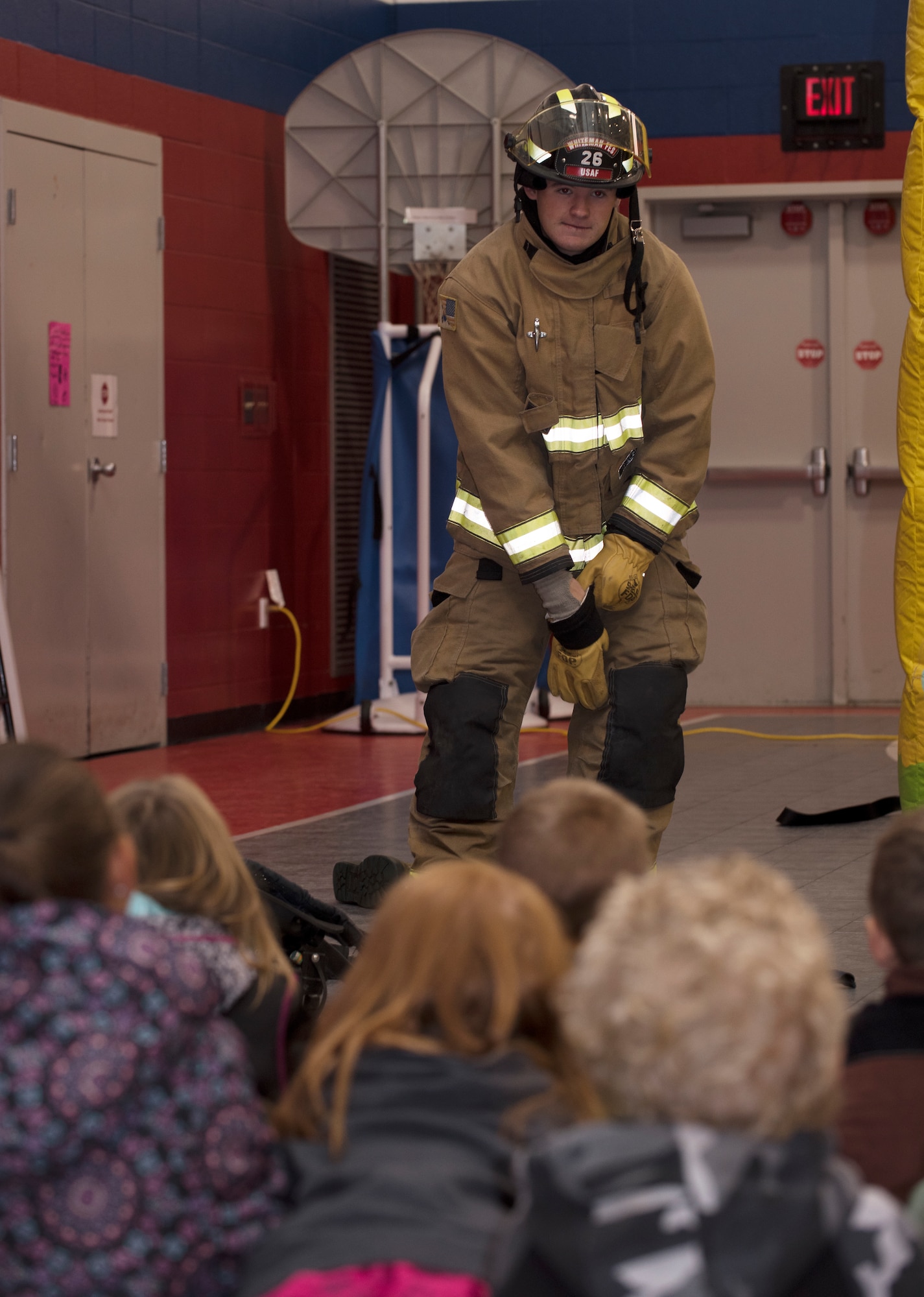 Airman 1st Class Jacob Adamson, assigned to the Fire and  Emergency Services Team at Whiteman Air Force Base, Missouri, demonstrates how he can don his uniform in 60 seconds to a first grade class to Whiteman Elementary on October 10, 2019. The 2019 Fire Prevention Week campaign theme is "Not Every Hero Wears a Cape. Plan and Practice Your Escape". (U.S. Air Force photo by Staff Sgt. Kayla White)