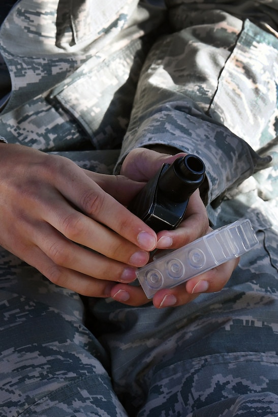 A service member holds a vape device near his lap.