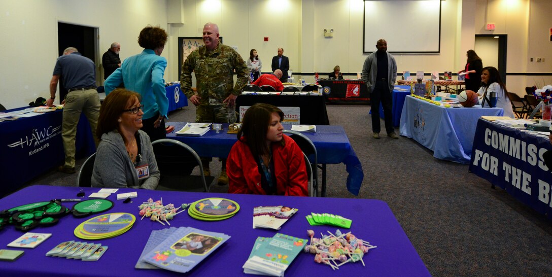 U.S. Air Force Col. Christopher J. King, 377th Air Base Wing vice commander talks with participants of the hero and exceptional family member program wellness and information fair on Oct. 11 in the Rio Grande Community Center. The purpose of the fair was to encourage the exploration of the latest services, technologies, and adaptive equipment to enrich the lives of those with disabilities. (U.S. Air Force photo by Jessie Perkins)