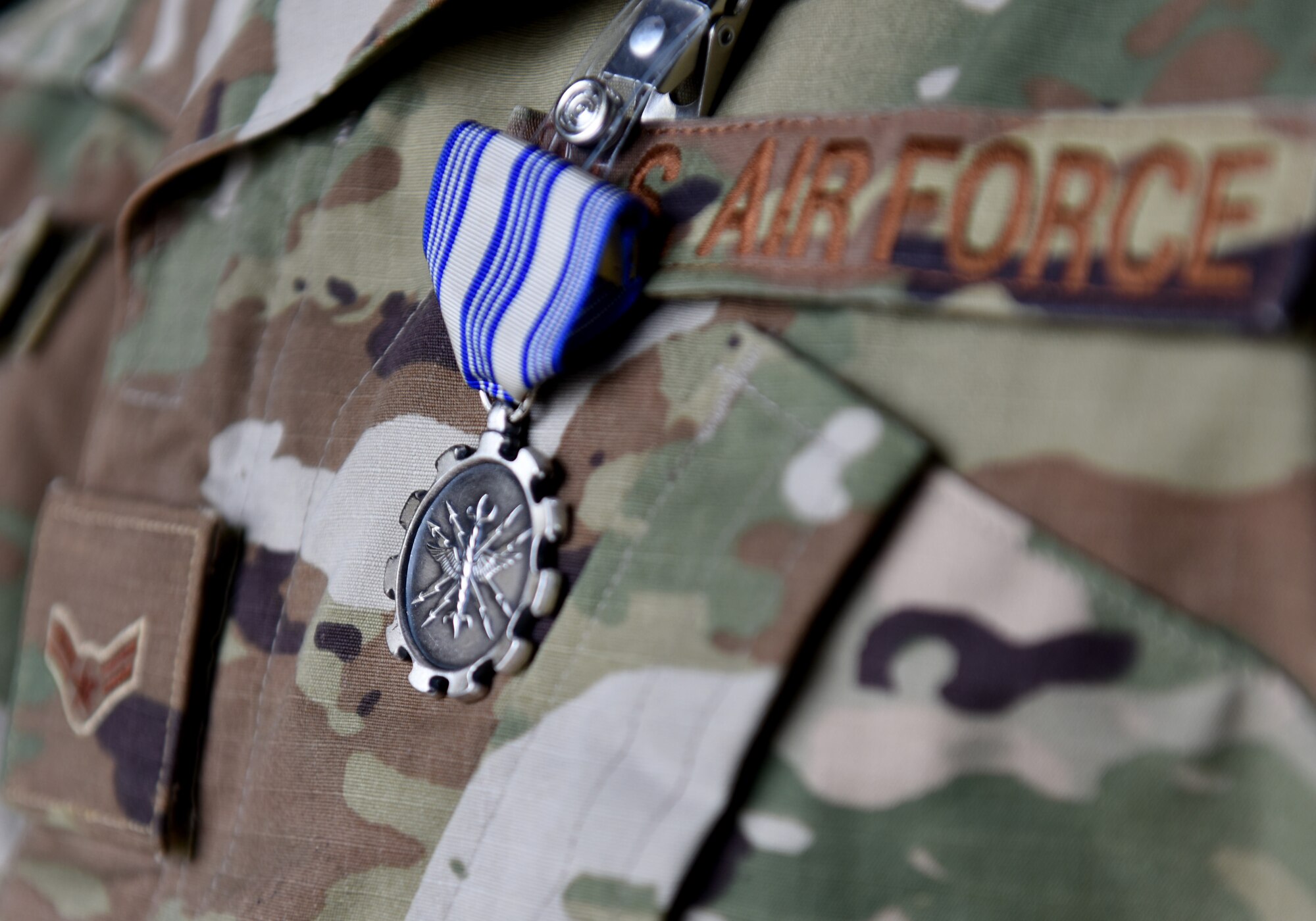 An Air Force Achievement Medal is pinned to an 748th Aircraft Maintenance Squadron Airman's uniform during an Air Force Achievement Medal presentation ceremony at Royal Air Force Lakenheath, England, Oct. 11, 2019. This medal is awarded to AF personnel for outstanding achievement or meritorious service rendered specifically on behalf of the Air Force. (U.S. Air Force photo by Airman 1st Class Madeline Herzog)