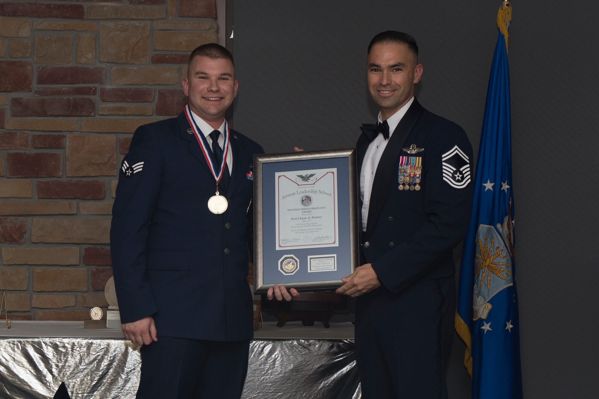 Senior Airman Chase Feeney, Airman Leadership School graduate, accepts the distinguished graduate award during the graduation of ALS class 19-7, October 10, 2019, on Holloman Air Force Base, N.M. The distinguished graduate award is presented to the top ten-percent of graduates for their performance in academic evaluations and demonstration of leadership. (U.S. Air Force photo by Airman 1st Class Kristin Weathersby)