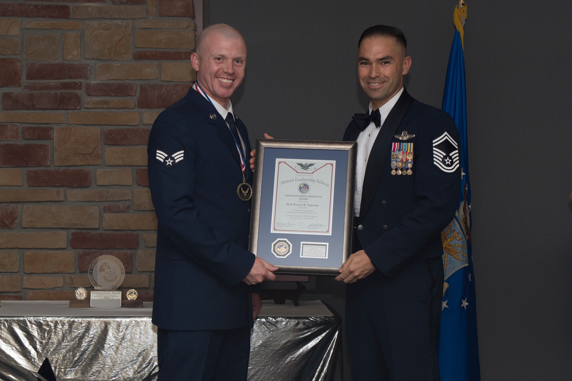Senior Airman Travis Coursey, Airman Leadership School graduate, accepts the distinguished graduate award during the graduation of ALS class 19-7, October 10, 2019, on Holloman Air Force Base, N.M. The distinguished graduate award is presented to the top ten-percent of graduates for their performance in academic evaluations and demonstration of leadership. (U.S. Air Force photo by Airman 1st Class Kristin Weathersby)