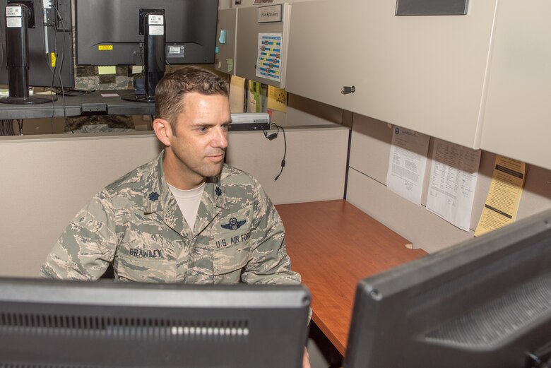 Lt. Col. Bob Brawley, the Individual Mobilization Augmentee (IMA), to the Division Chief, Plans, Programs and Readiness at Headquarters Readiness and Integration Organization (HQ RIO),  prepares emergency notifications for potential typhoon Hagibis on Oct. 11, 2019, at Buckley Air Force Base, Colo. HQ RIO members such as Brawley are focused on improving inefficient processes and providing outstanding administrative support for the IMA community, making it easier for them to serve. (U. S. Air Force photo by Master Sgt. Eric Amidon)
