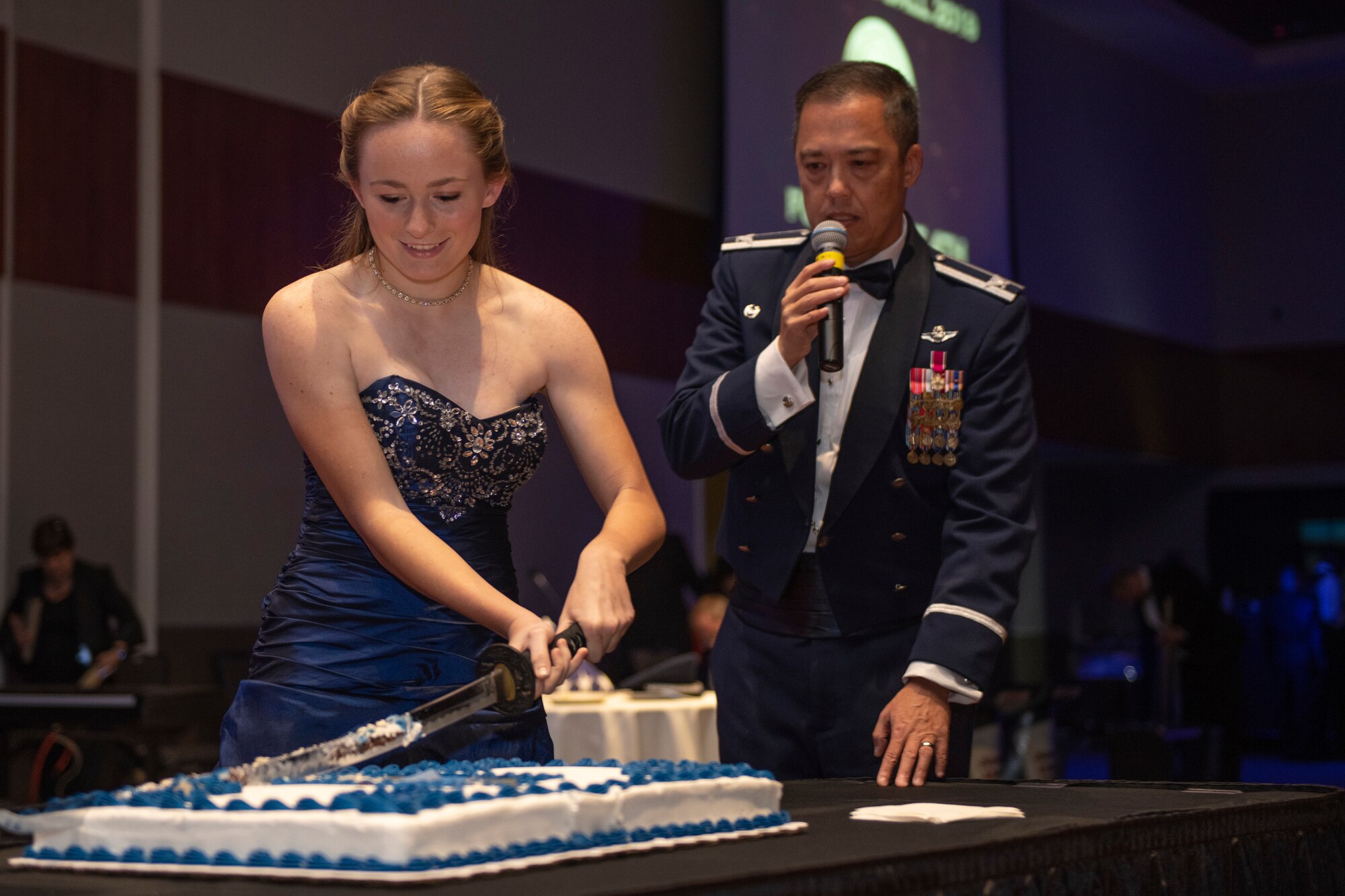 Airman cuts the first slice of cake during the Air Force Ball