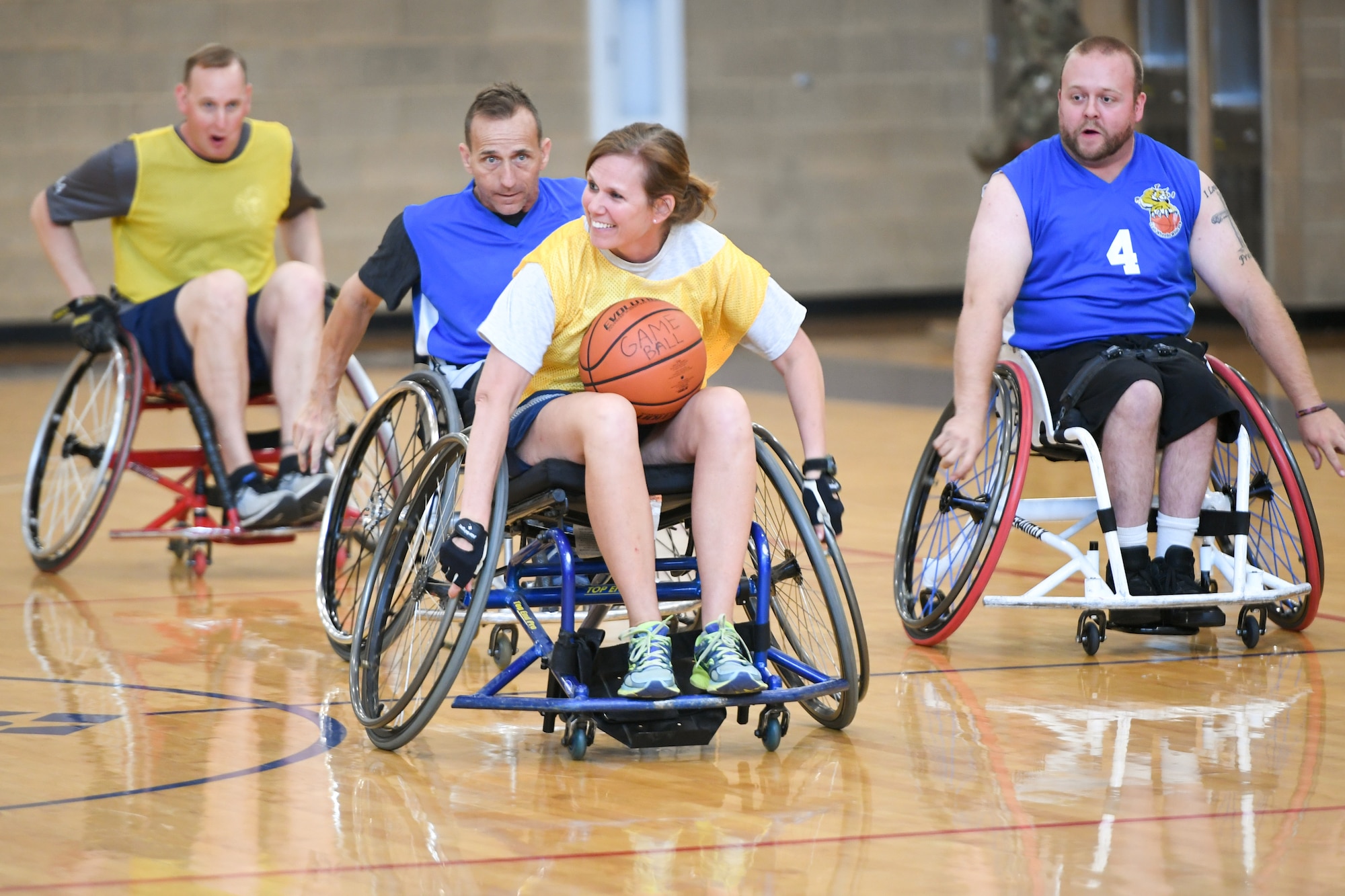 Colonel Regina Sabric, 419th Fighter Wing commander, runs with the ball during a wheelchair basketball game Oct. 9, 2019 at Hill Air Force Base, Utah. Leaders from Hill's units faced off against the Ogden Wheelin' Wildcats, a semi-professional wheelchair basketball team, to celebrate National Disability Employment Awareness Month. (U.S. Air Force photo by Cynthia Griggs)
