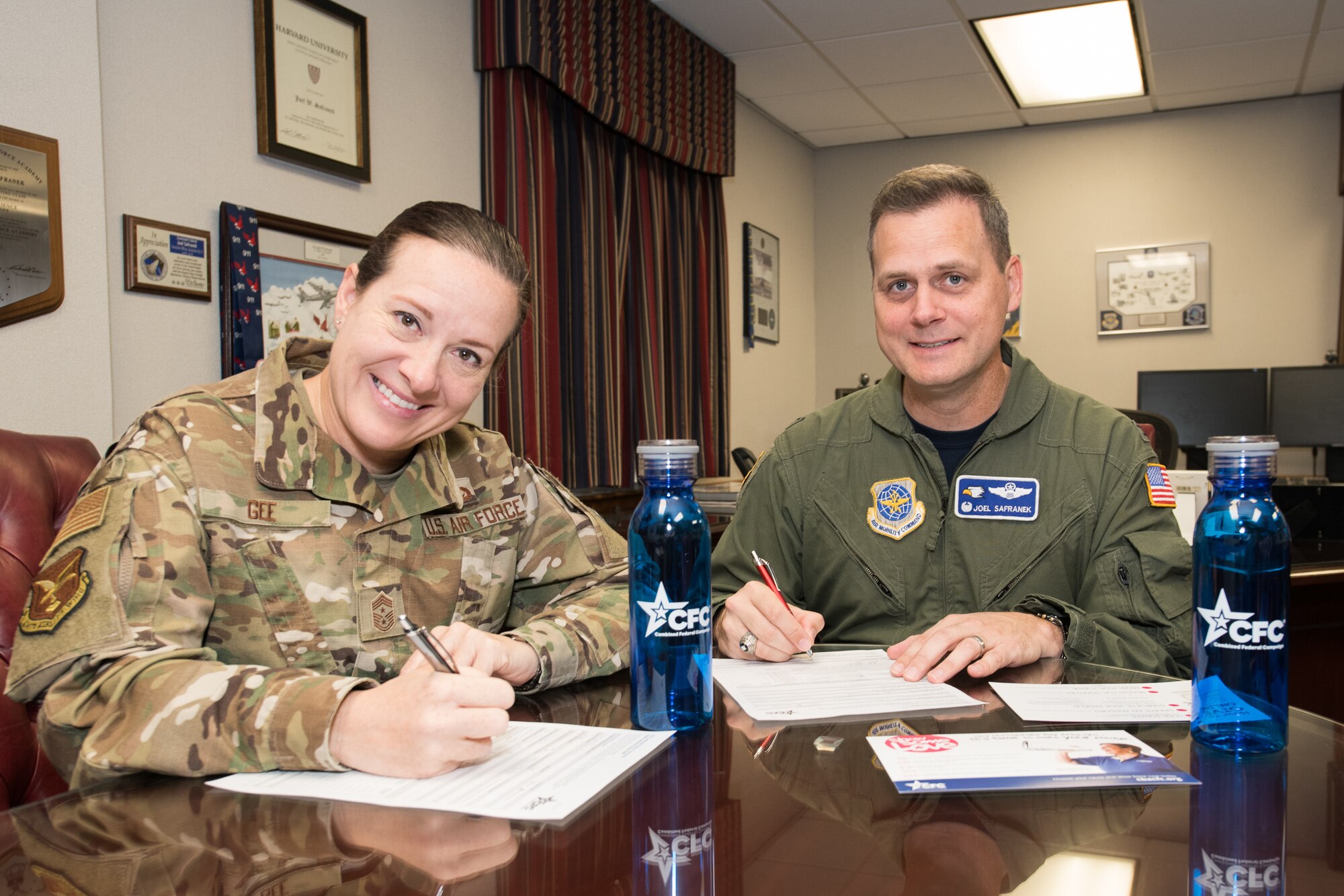 Col. Joel Safranek, right, 436th Airlift Wing commander, and Chief Master Sgt. Shae Gee, 436 AW command chief,  sign their 2019 Combined Federal Campaign pledge forms Oct. 11, 2019, at Dover Air Force Base, Del. The campaign runs from Oct. 7 through Nov. 18, 2019. Interested donors can see their unit representative or visit www.cfcgiving.opm.gov. (U.S. Air Force photo by Mauricio Campino)