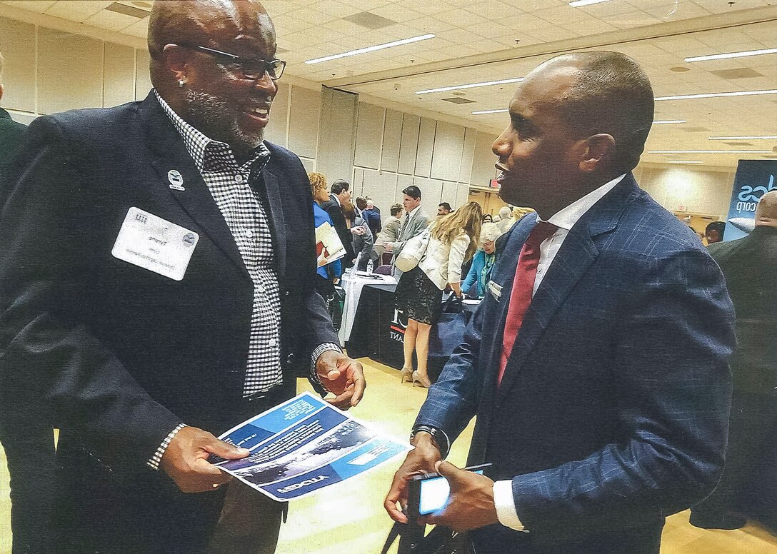 Tyrone Lyles, Defense Logistics Agency Troop Support AbilityOne and UNICOR program manager, left, speaks with a business owner during one of many outreach events attended by the Small Business Office throughout the year.