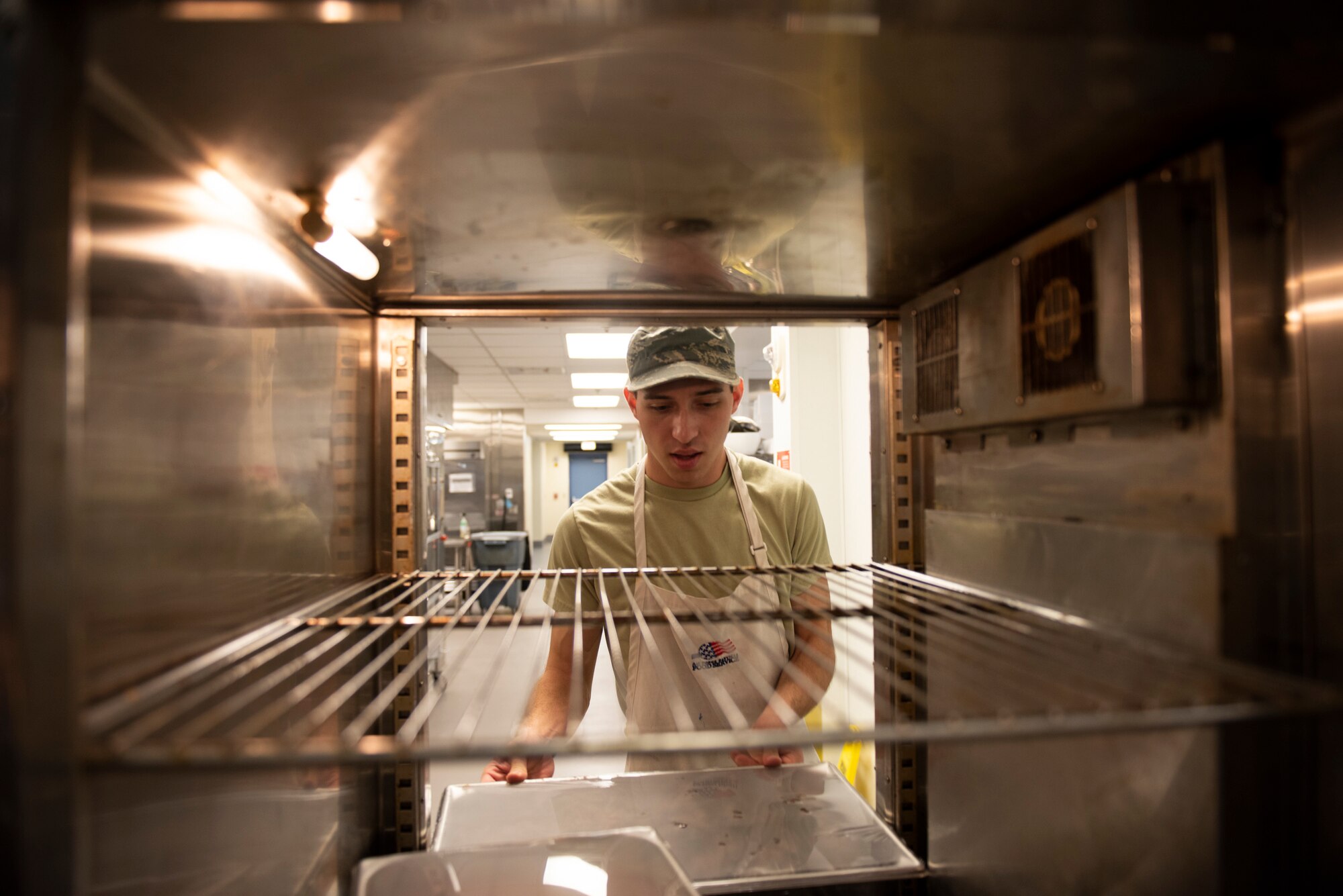 Airman 1st Class Colten Mangione, 23d Force Support Squadron (FSS) food services apprentice, moves food into a warmer Oct. 8. 2019, at Moody Air Force Base, Ga. Airmen assigned to the Georgia Pines Dining Facility prepare food, perform quality-control inspections and provide meal service for more than 700 Airmen daily. FSS Airmen also provide support in the areas of child development, food service, lodging, recreation, fitness, mortuary affairs and youth services as well as promoting individual, unit, family and community well-being. (U.S. Air Force photo by Airman Elijah M. Dority)
