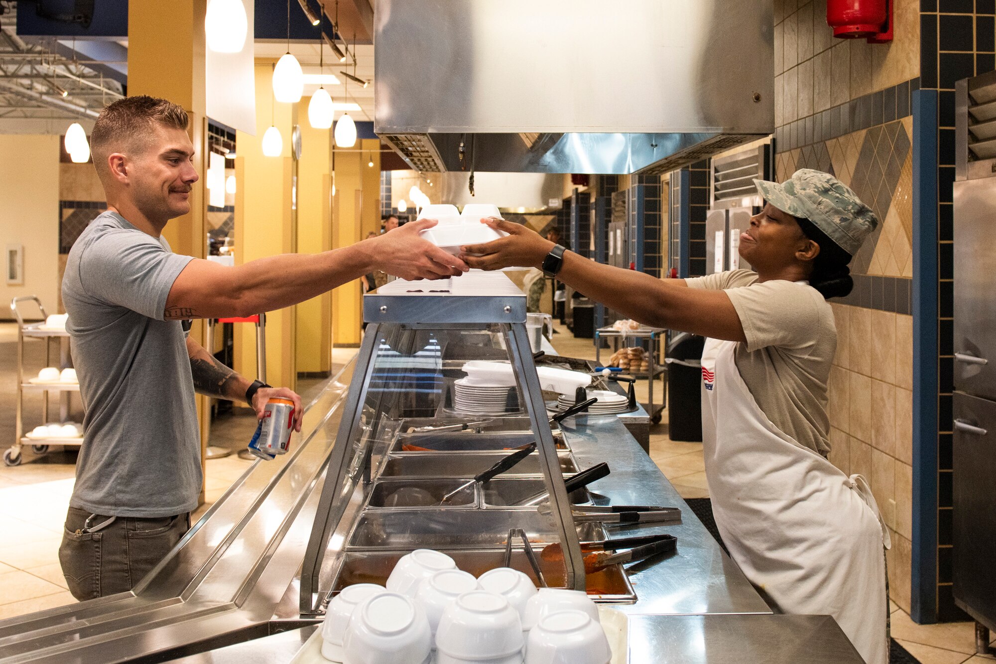 Staff Sgt. Tyra Middlebrooks, right, 23d Force Support Squadron (FSS) dining facility (DFAC) shift leader, serves a customer Oct. 9, 2019, at Moody Air Force Base Ga. Airmen assigned to the Georgia Pines DFAC prepare food, perform quality-control inspections and provide meal service for more than 700 Airmen daily. FSS Airmen also provide support in the areas of child development, food service, lodging, recreation, fitness, mortuary affairs and youth services as well as promoting individual, unit, family and community well-being. (U.S. Air Force photo by Airman Elijah M. Dority)