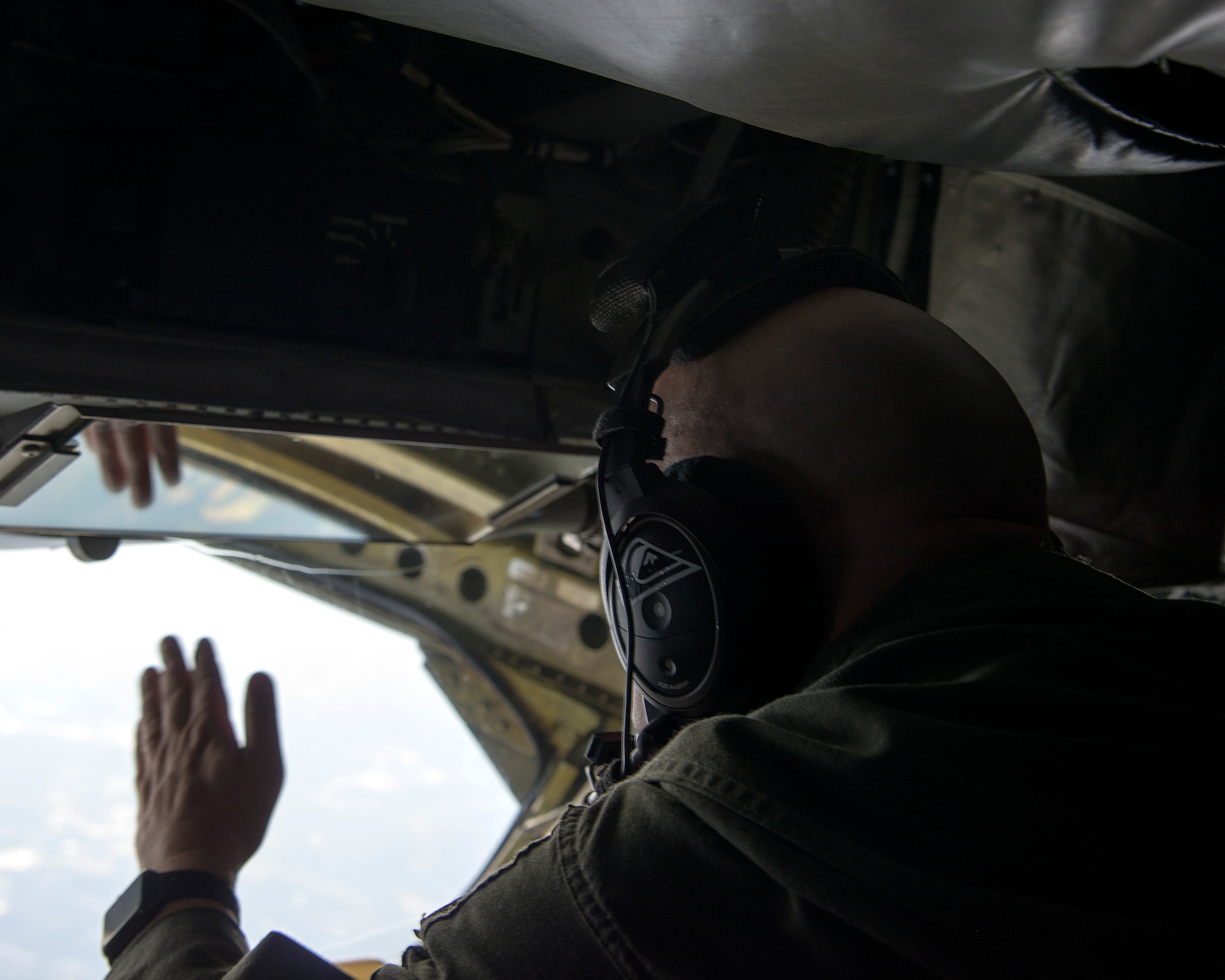 U.S. Air Force Senior Master Sgt. Justin Poteet, a 50th Air Refueling Squadron (ARS) boom operator, waves at the pilot of a United States Air Force Air Demonstration Squadron “Thunderbird” Oct. 14, 2019. The 50th ARS took flight to complete aerial refuelings of the Thunderbirds.