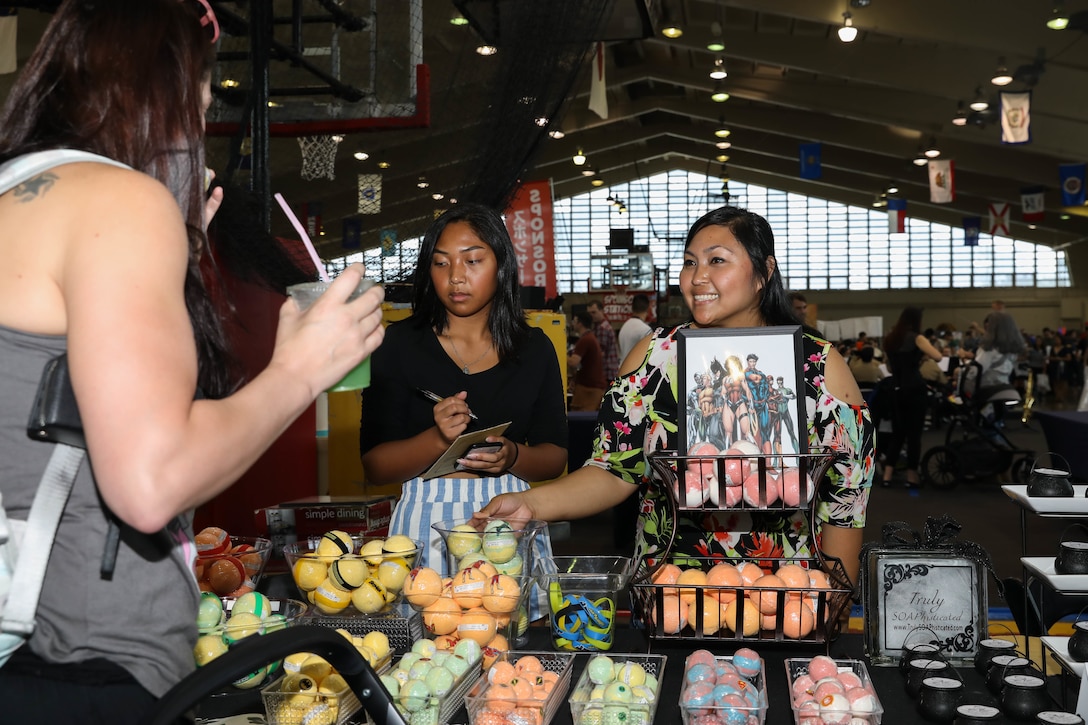 Gina Ferrer, right, a family medicine nurse with U.S. Naval Hospital Okinawa, and her daughter greet attendees at Camp Foster Fieldhouse during Comic Con Okinawa, Japan, Oct. 13, 2019. This annual event began in 2011 and is catered to comic book fans, movie fans, artists, and video gamers to meet and greet with comic industry professionals and celebrities.The event was open to members of the U.S. and local communities.