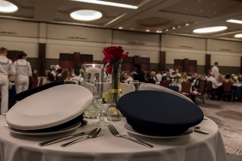 Hats from each branch of the military rest on a prisoner of war and missing in action table during the Joint Base Charleston Navy Ball Oct. 13, 2019 at the Charleston Area Convention Center, S.C. The table is set to remind attendees to honor the sacrifices of POWs and those who are MIA. Service members attended the ball to celebrate the Navy’s 244th birthday.