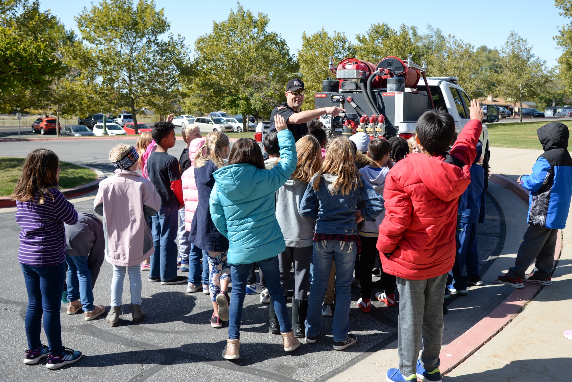 Doran Smith, Fire and Emergency Services at Hill Air Force Base, Utah, talks to Hill Field Elementary students about fire safety Oct. 10, 2019, in front of the department's new heavy-brush truck. This was one of the numerous outreach events base firefighters sponsored for Fire Prevention Week Oct. 6-12. (U.S. Air Force photo by Cynthia Griggs)