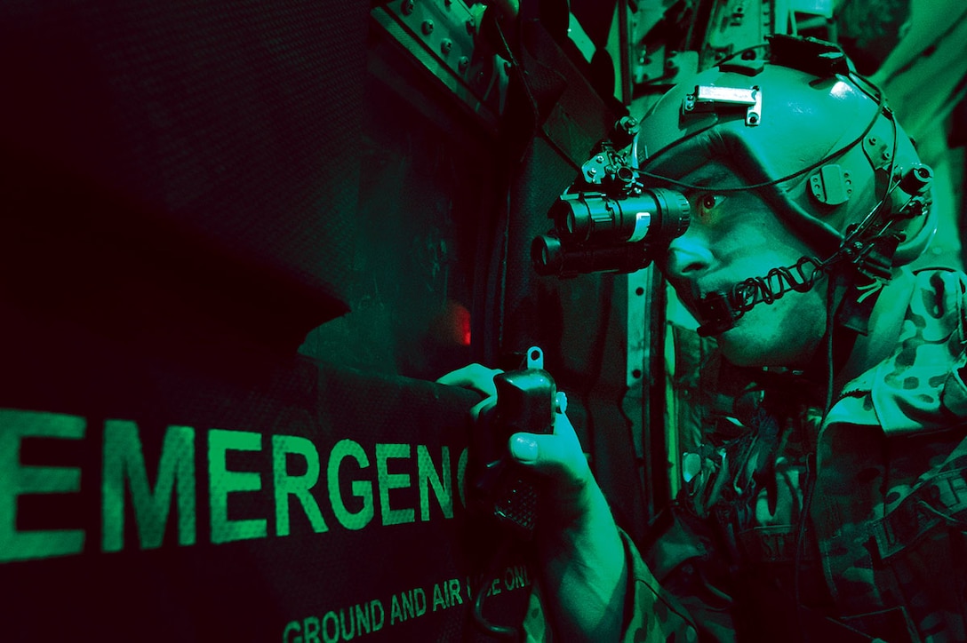 U.S. Air Force Senior Airman Larry Webster, a loadmaster with the 774th Expeditionary Airlift Squadron, scans for threats using night vision goggles aboard a C-130H Hercules aircraft after completing a cargo airdrop mission over Ghazni province, Afghanistan, Oct. 7, 2013. (DoD photo by Master Sgt. Ben Bloker, U.S. Air Force/Released)