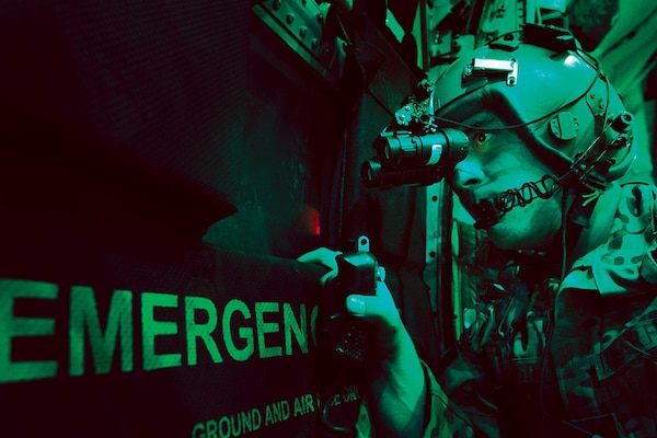 In 2013, A U.S. Air Force loadmaster scans for threats using night vision goggle aboard a C-130 aircraft after completing a cargo drop over Ghazni, province in Afghanistan. (U.S. Air Force/ Ben Bloker)