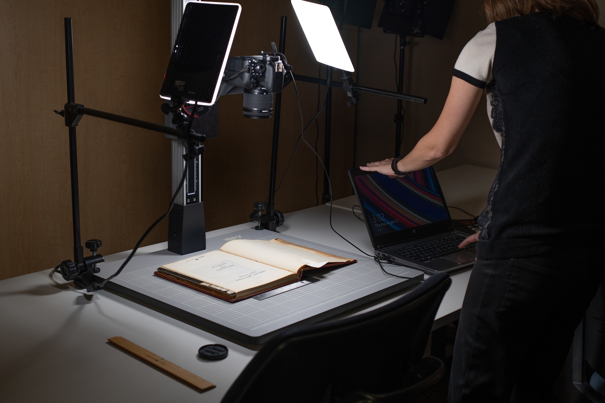 Alexandra Aldridge, Air University Library employee, demonstrates one of the digitization methods the library is using to make their resources available DOD-wide, Aug. 22, 2019, on Maxwell Air Force Base, Alabama. The AUL is currently working on digitizing more than 2,500 linear feet of resources, providing the larger Air Force and DOD communities with access to their research and products regardless of location.