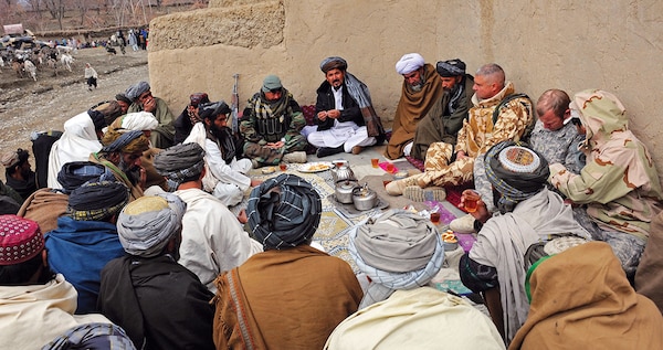 In 2011, Afghan government and International Security Assistance Force officials take part in a shura with elders in Zabul province, Afghanistan. The Zabul Provincial Reconstruction Team visited the village to talk with elders and help Afghan National Security Forces distribute winter supplies. (U.S. Air Force/Brian Ferguson)