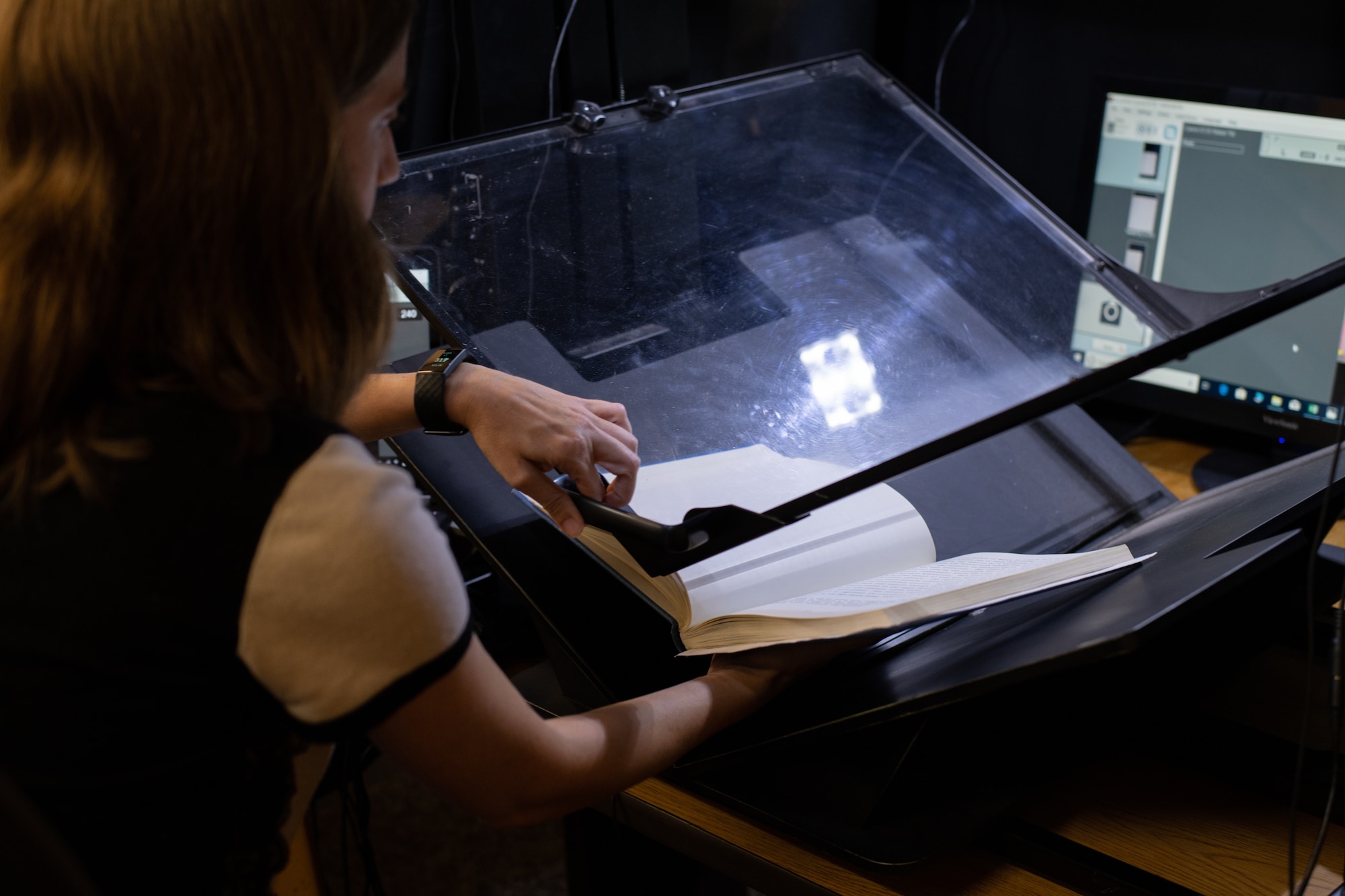 Alexandra Aldridge, Air University Library employee, demonstrates one of the digitization methods the library is using to make their resources available DOD-wide, Aug. 22, 2019, on Maxwell Air Force Base, Alabama. The AUL is currently working on digitizing more than 2,500 linear feet of resources, providing the larger Air Force and DOD communities with access to their research and products regardless of location.
