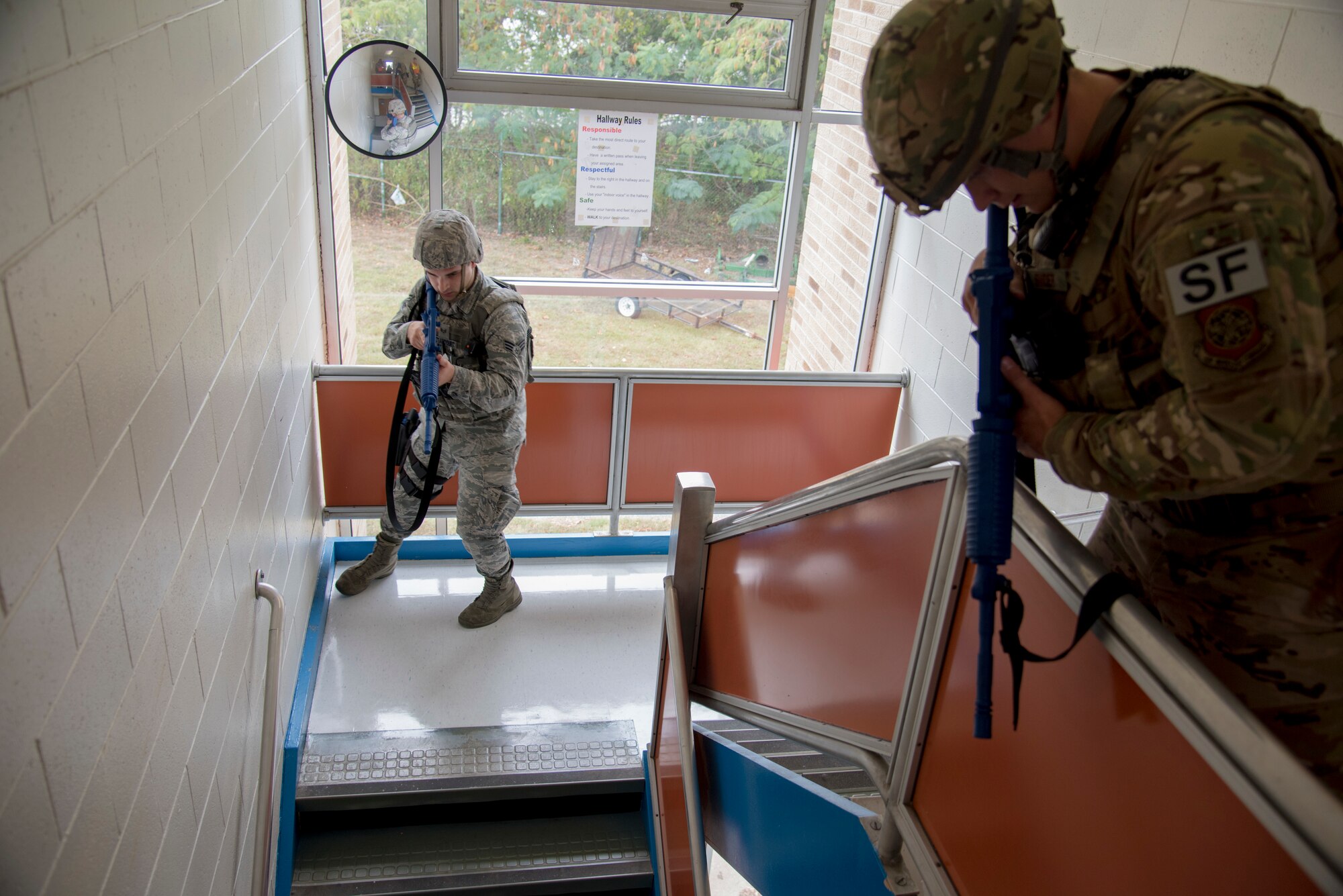 Senior Airman Miguel Bettencourt (left), 436th Security Forces Squadron response member, and Staff Sgt. Harold Snyder, 436th Security Forces Squadron flight sergeant, clear a stairwell Oct. 11, 2019, at Dover Air Force Base, Del. Every location inside the schools was swept for hostiles and noncombatants. (U.S. Air Force photo by Airman 1st Class Jonathan Harding