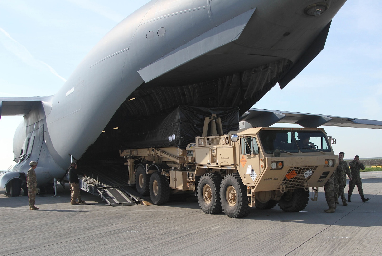 American troops offload a Terminal High Altitude Area Defense launcher from a C-17 Globemaster III