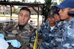 Staff Sgt. Edgar Castro, joint security forces, explains crime scene processing paperwork to students from the La Paz Police Academy during a training course here. The crime scene processing class is one in a series of classes taught this year, with other lessons involving handcuff procedures, high-risk traffic stops and riot control. (U.S. Air Force photo/Tech. Sgt. Sonny Cohrs)