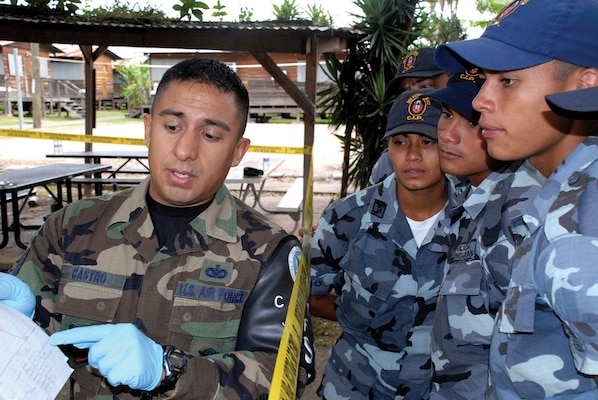 An airman assigned to Joint Task Force Bravo—Joint Security Forces in Honduras explains crime scene processing to Honduran police. The instruction is part of a series of classes that teach handcuff procedures, high-risk traffic stops, and riot control. (U.S. Air Force/ Sonny Cohrs).