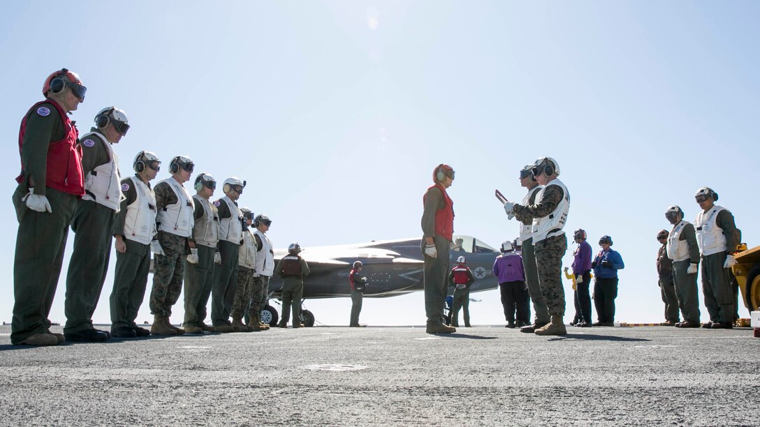 U.S. Marine Corps Cpl. John Finke is re-enlisted by Maj. Gen. Kevin M. Iiams, commanding general of 3rd Marine Aircraft Wing (MAW), aboard the amphibious assault ship USS America (LHA 6) in the Eastern Pacific, Oct. 6, 2019. Finke, from New Berlin, Illinois, is an ordnance Marine, with Marine Fighter Attack Squadron (VMFA) 122, Marine Aircraft Group 13, 3rd MAW. (U.S. Marine Corps photo by Lance Cpl. Juan Anaya)