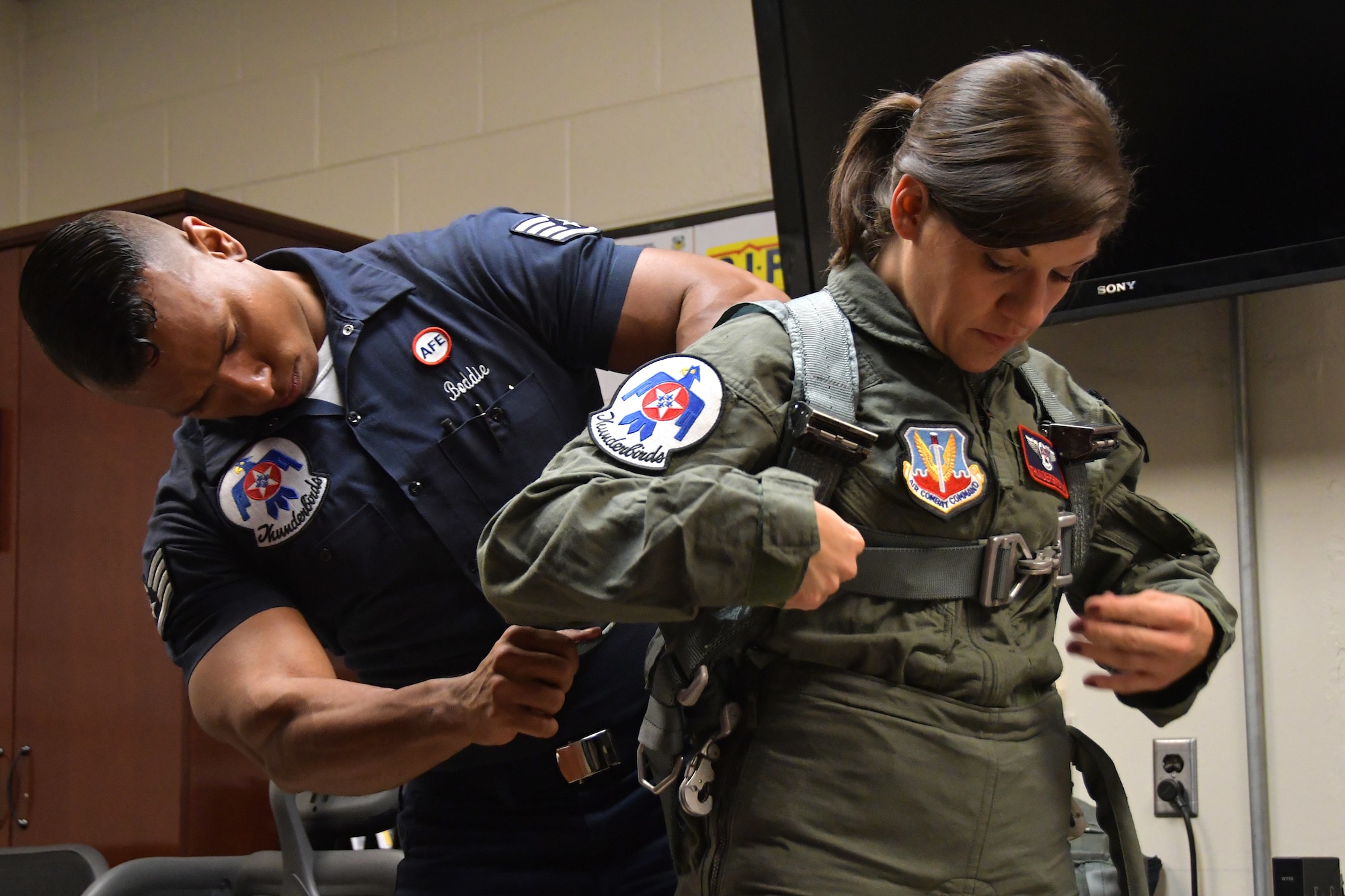 Staff Sgt. Kyle Boddie, U.S. Air Force Thunderbirds aircrew flight equipment technician, helps Tracey Pendley with her anti-gravity flight suit at Dobbins Air Reserve Base, Ga. on Oct. 11, 2019. The Hometown Hero program allows exceptional community members to be nominated for a familiarization flight in a Thunderbirds jet, an F-16 Fighting Falcon. (U.S. Air Force photo/Airman Kendra A. Ransum)